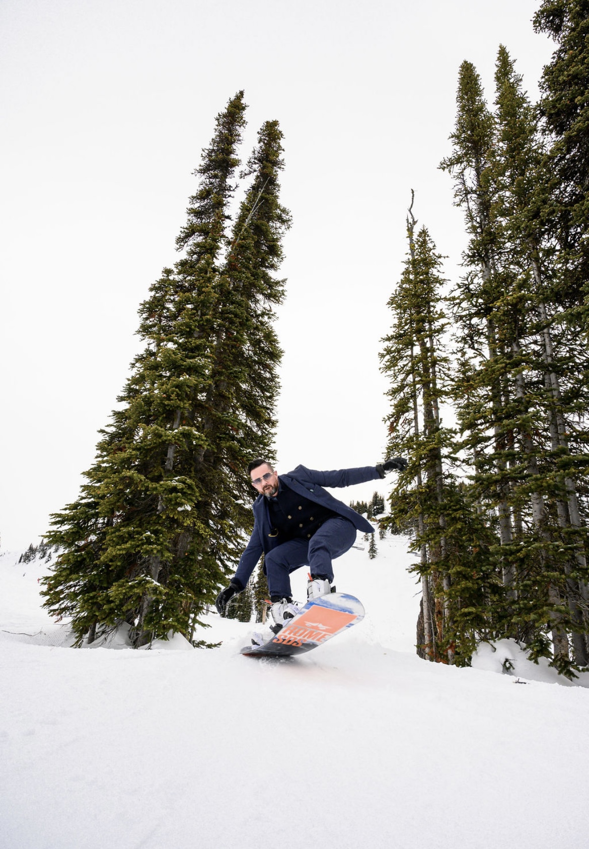 Paul mid-jump on a snowboard, in a suit